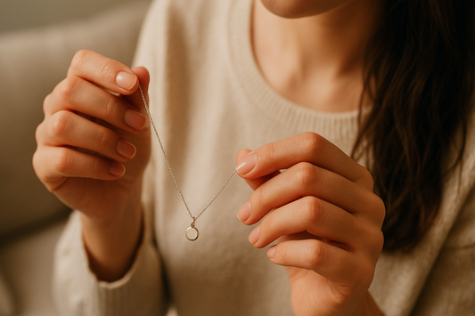 Frau hält zarte Kette mit Anhänger – Symbol für Liebe, Erinnerung und Verbundenheit als Geschenk.
