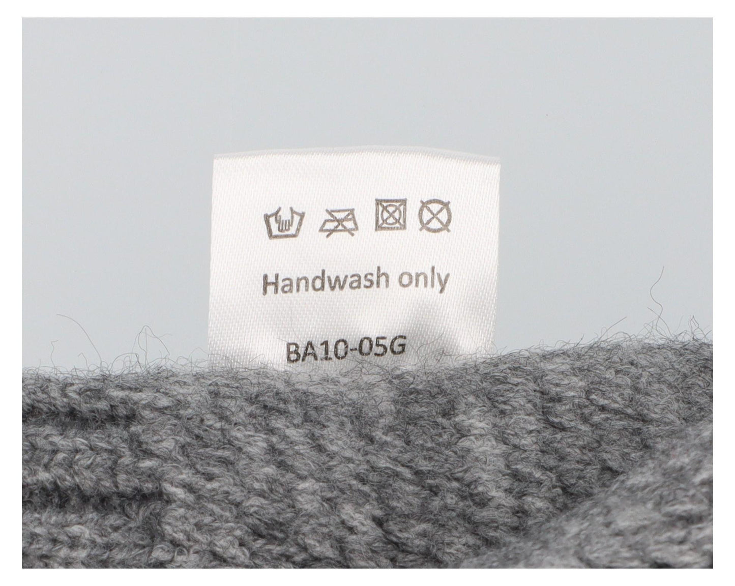 graue Strickmütze mit eingestickter Notenlinie und Schneeflocken